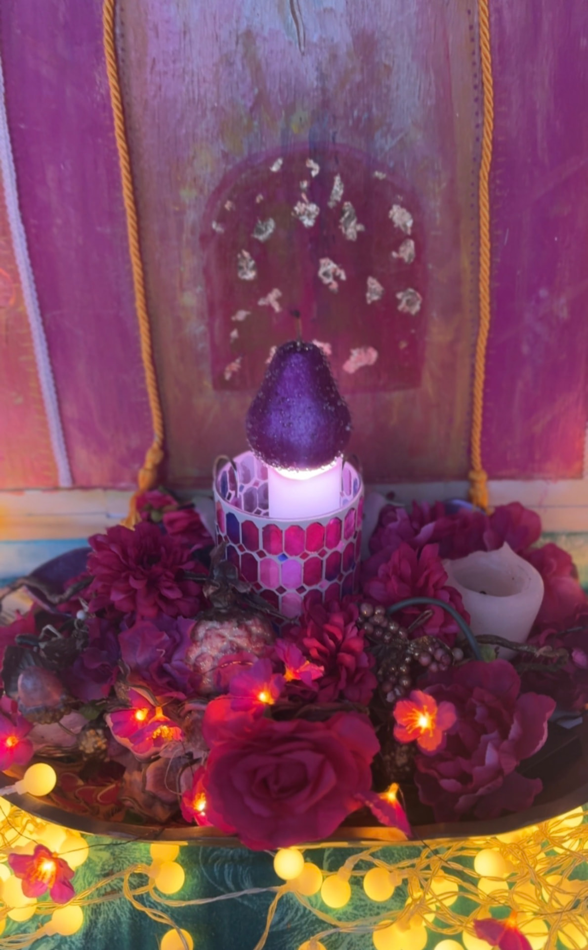 A luminous purple pear surrounded by roses at the altar