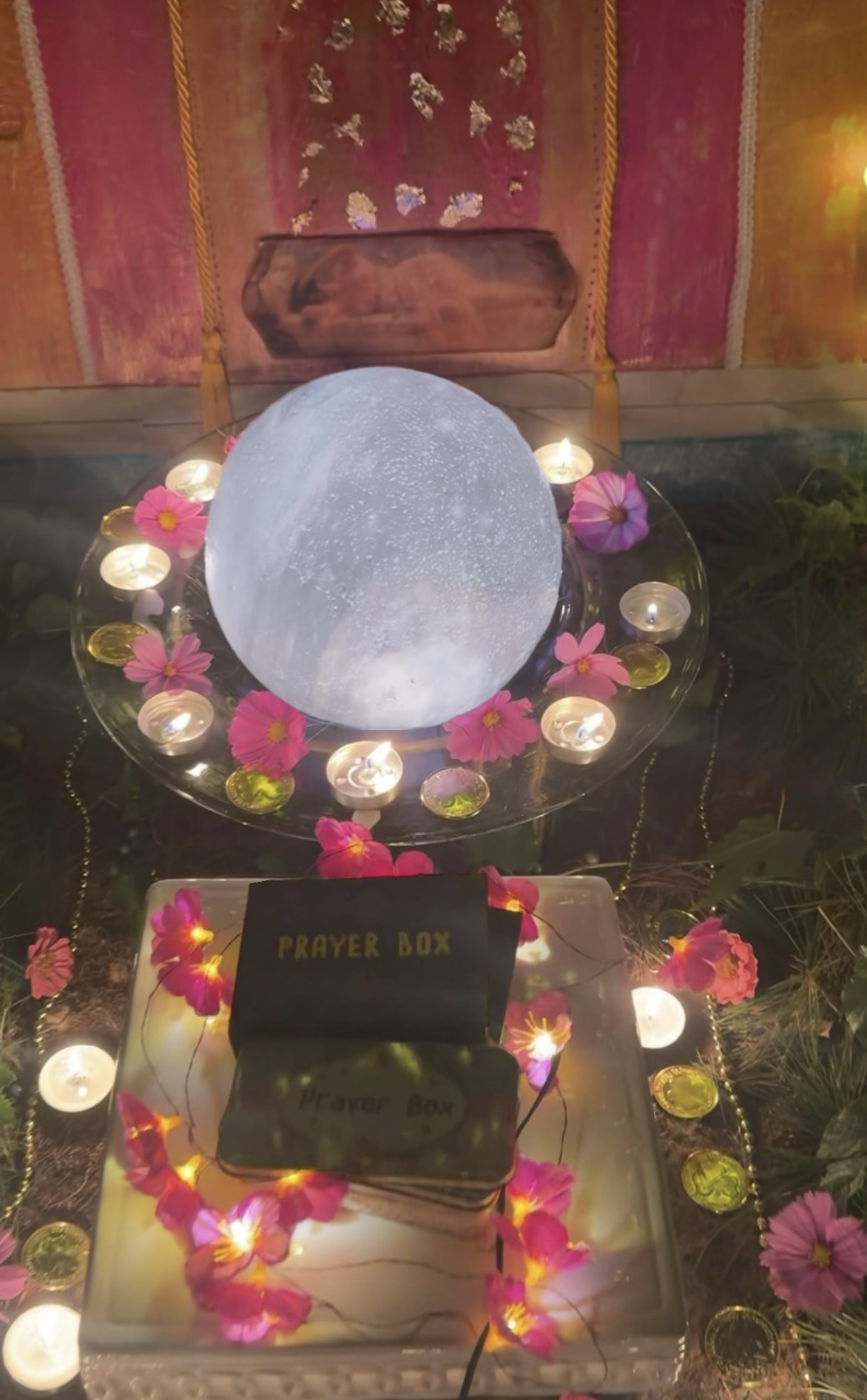A luminous Moon orb nestled among flowers and candles