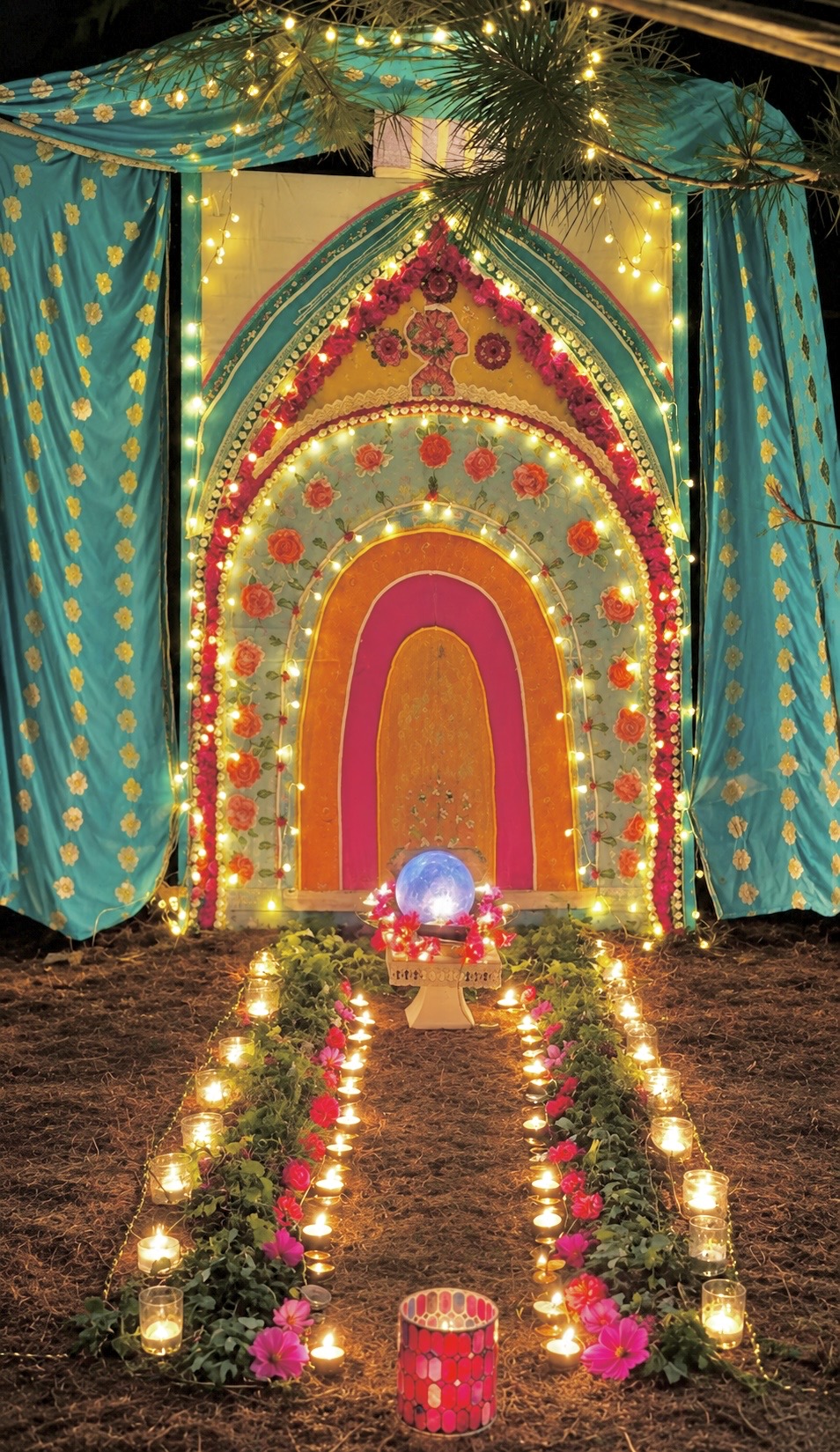 A glowing altar for The Divine Mother: rainbow arch of flowers and lights, crystal orb, and a candlelit path of cosmos