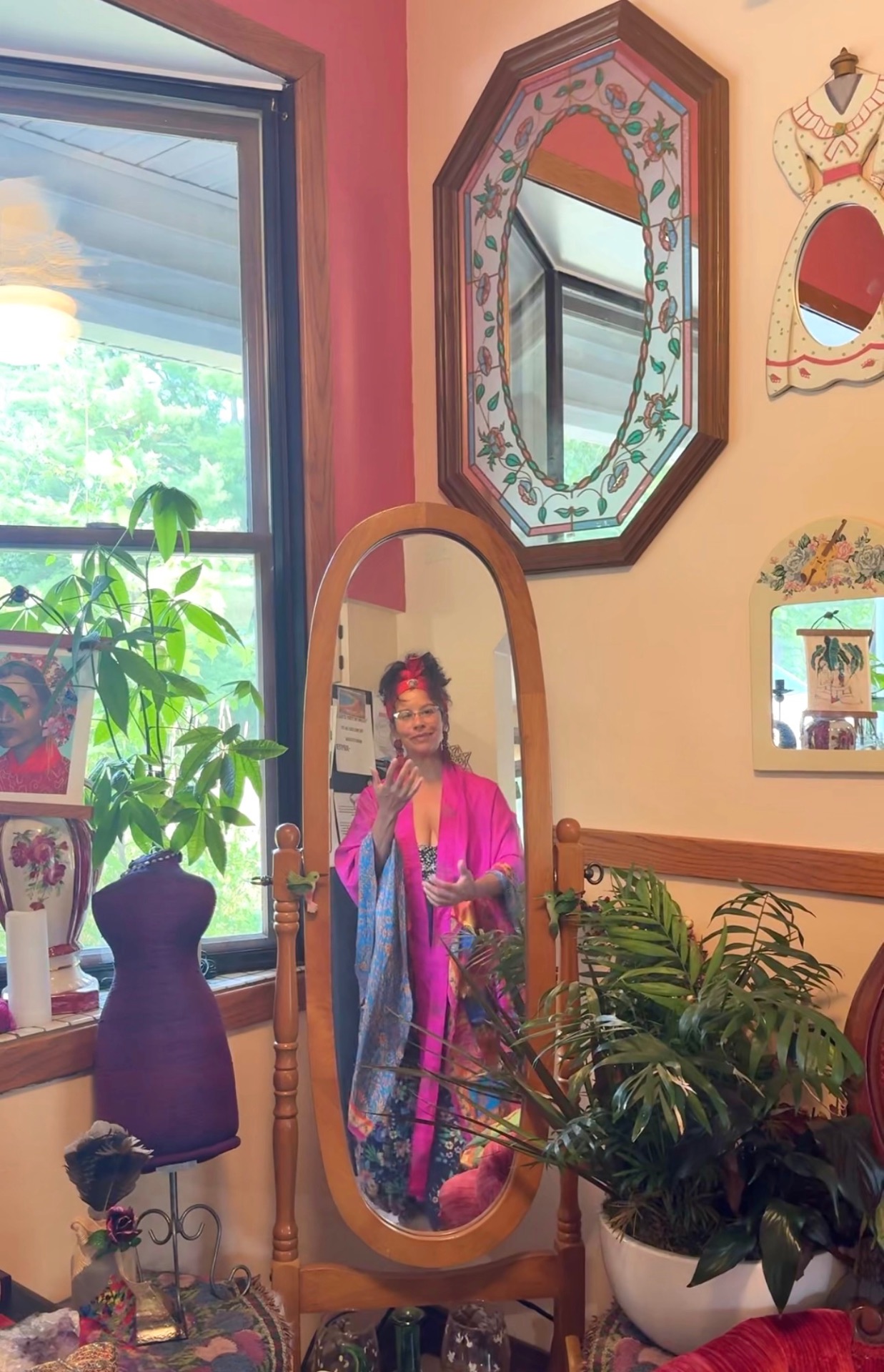 A sunlit room of mirrors, plants and hanging silks